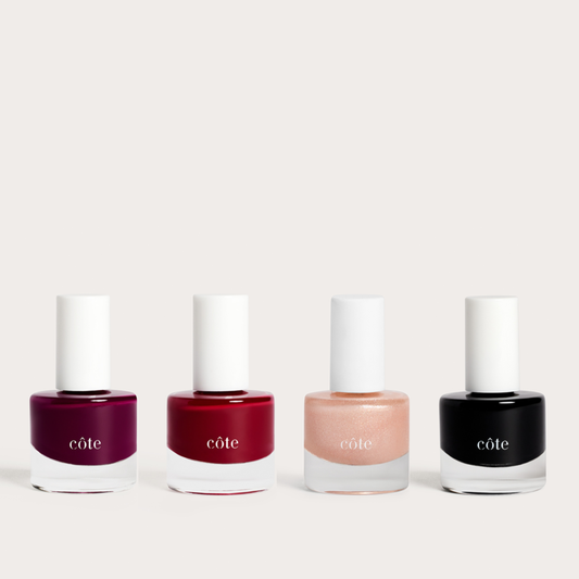 Dark Muse wine and black non-toxic nail polish set by Côte Beauty, four bottles in magenta, garnet, peach shimmer, and black.