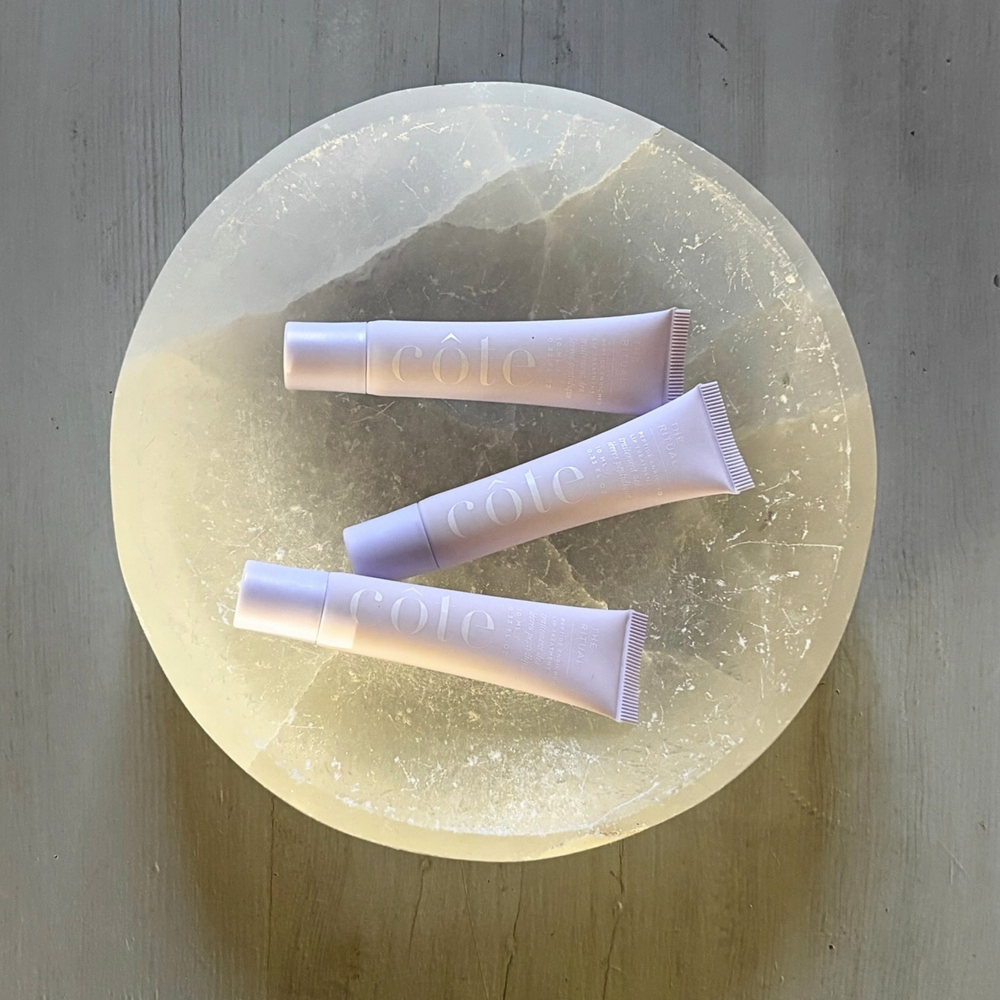 Three tubes of Côte Beauty The Ritual Peptide Lip Treatment Non-Toxic Hydrating Lip Care on a marble tray.