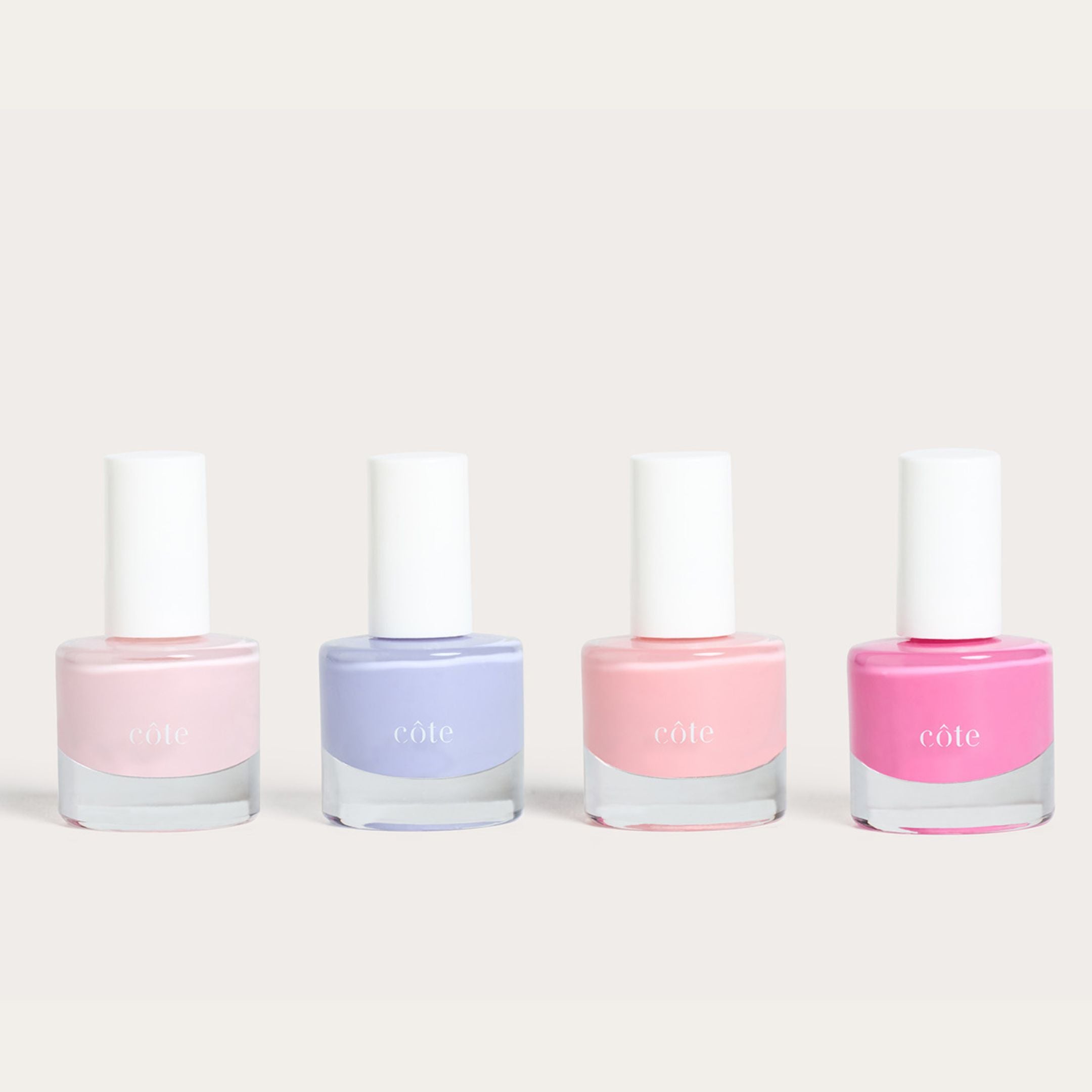 Côte Beauty Color Crush Nail Polish Collection, Including Moonbeam Soft Blush Pink , Sugar Côte Soft Lavender, Pink Clouds Sheer Petal Blush and Hotshot True Bright Pink Non-Toxic Nail Polish bottles.